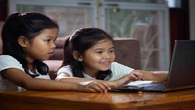 Two asian child girls using notebook to learning online technology with her sister together. Concept of online education, social distance learning at home during quarantine and school holidays.
