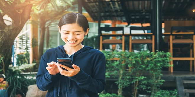 Smile,Asian,Young,Woman,Using,Smartphone,Cell,At,A,Coffee